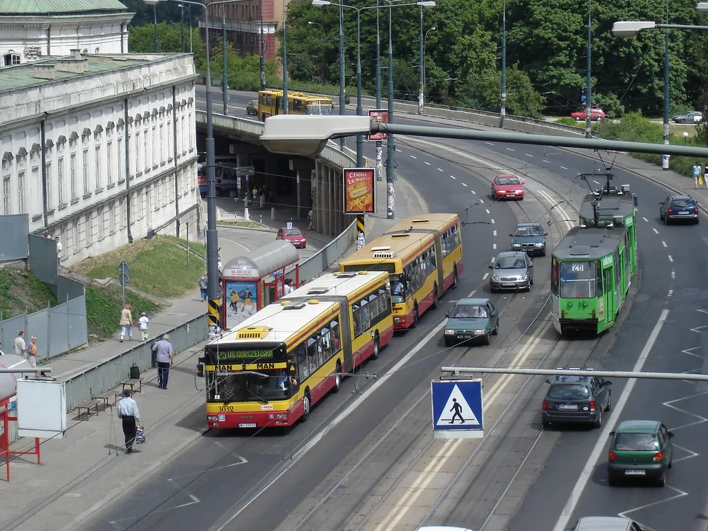 Trams and buses on a busy street in central Warsaw.