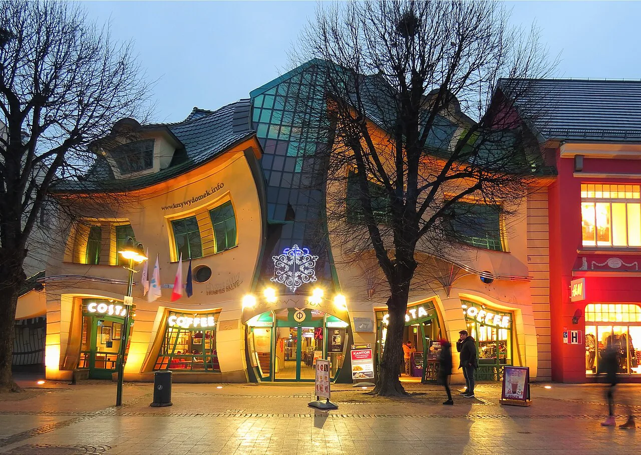 The Crooked House in Sopot lit up in the evening.