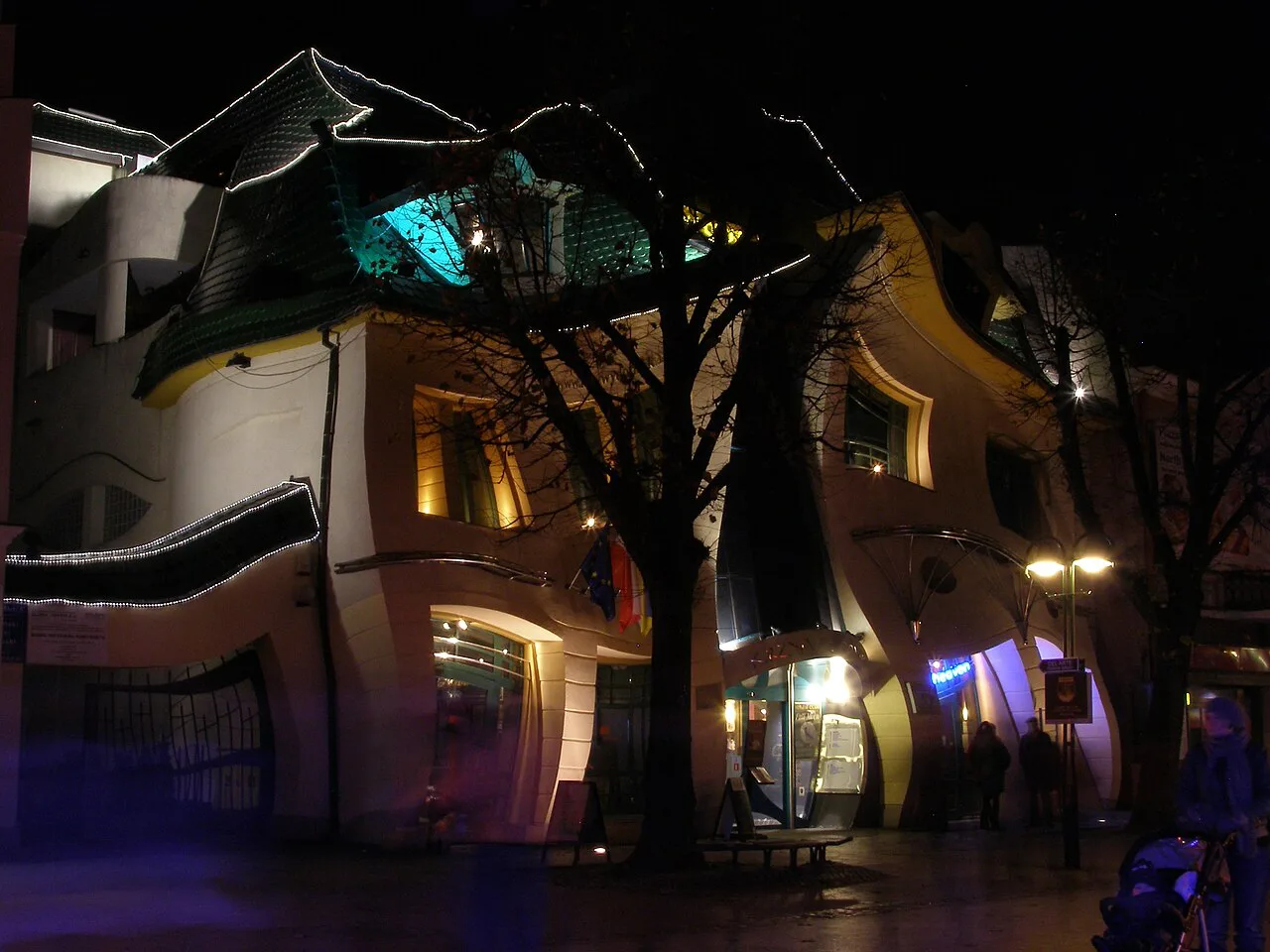 The Crooked House (Krzywy Domek) in Sopot lit up at night.
