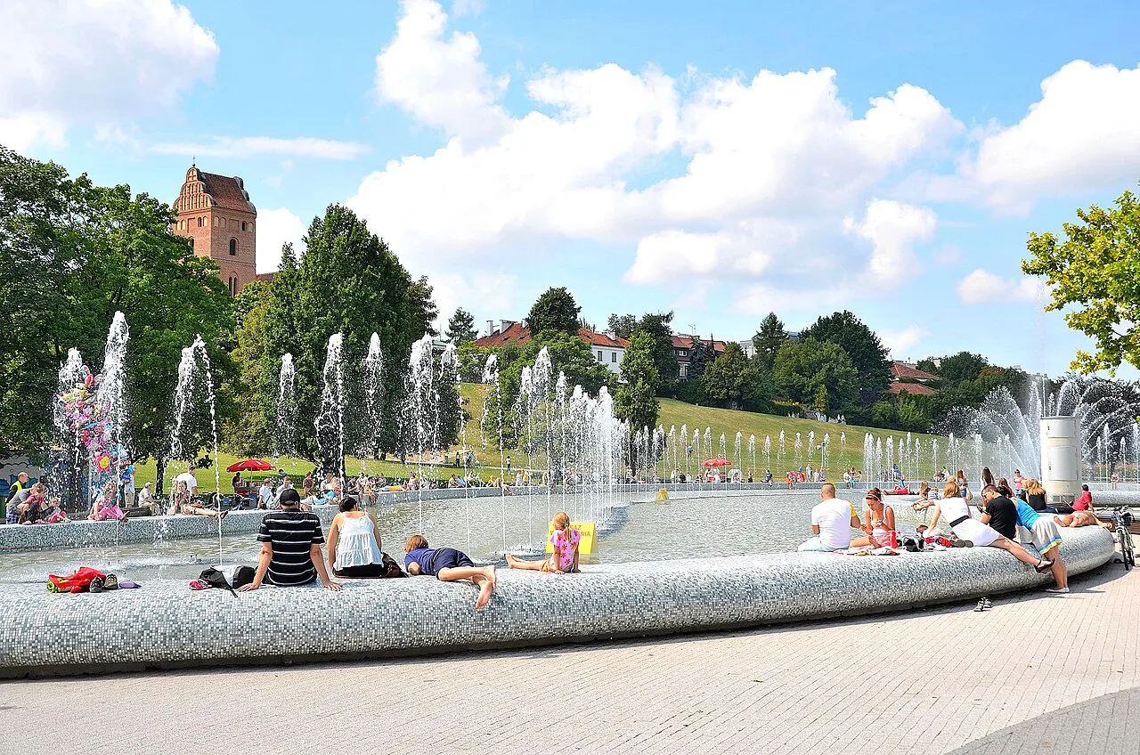 Visitors at the Multimedia Fountain Park in Warsaw on a sunny day.