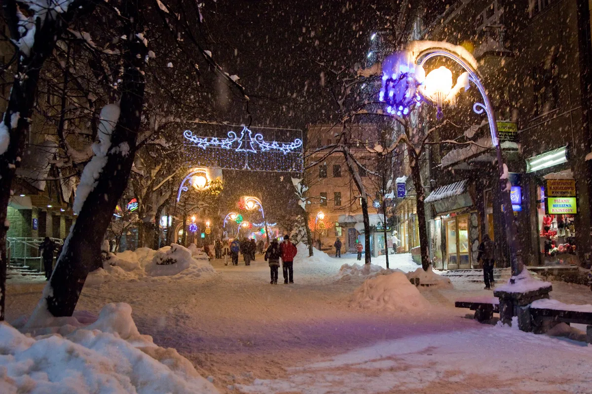 Krupówki Street in Zakopane at night in falling snow.