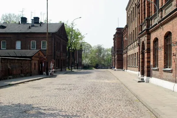A cobbled street of red-brick buildings in Księży Młyn, Łódź.