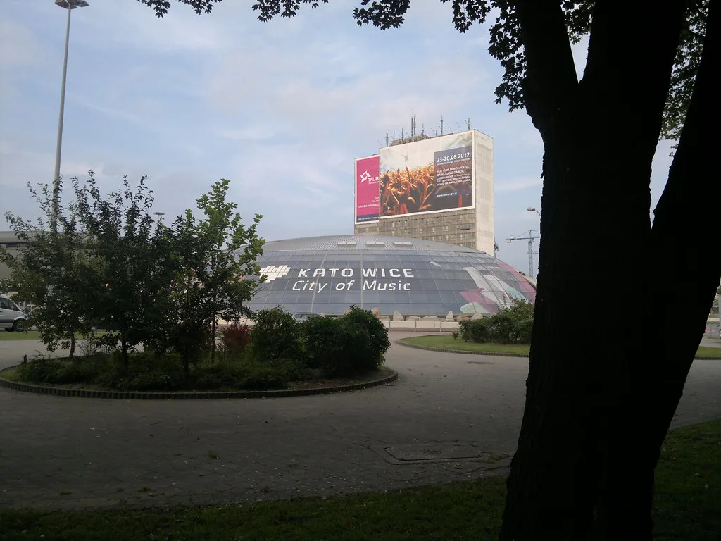 A Katowice 'City of Music' sign beside a city-centre roundabout.
