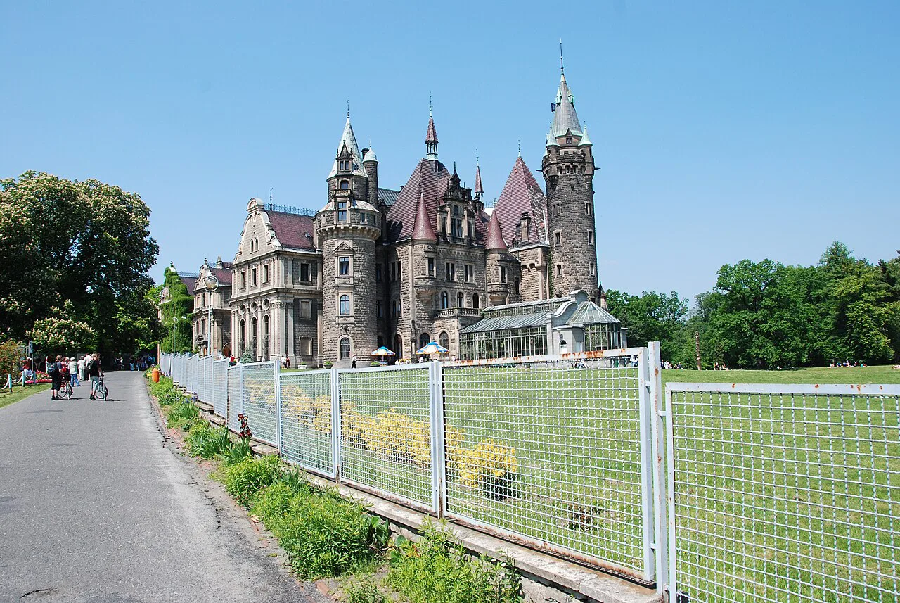 Moszna Castle seen from the park path.
