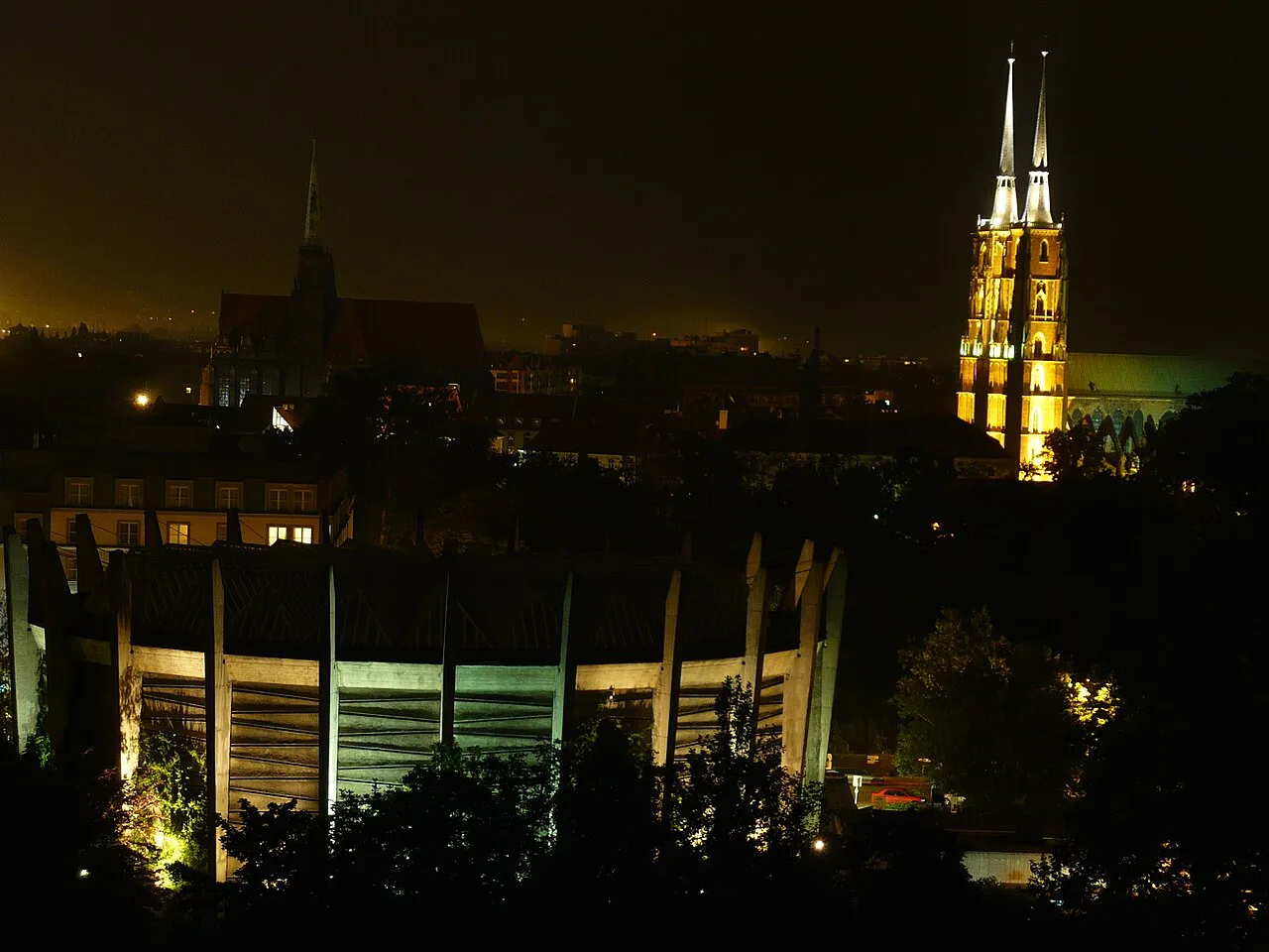 The Racławice Panorama rotunda at night with Wrocław Cathedral behind.