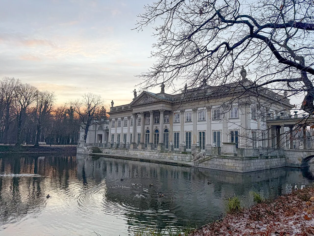 The Palace on the Isle in Warsaw reflected in the surrounding water.