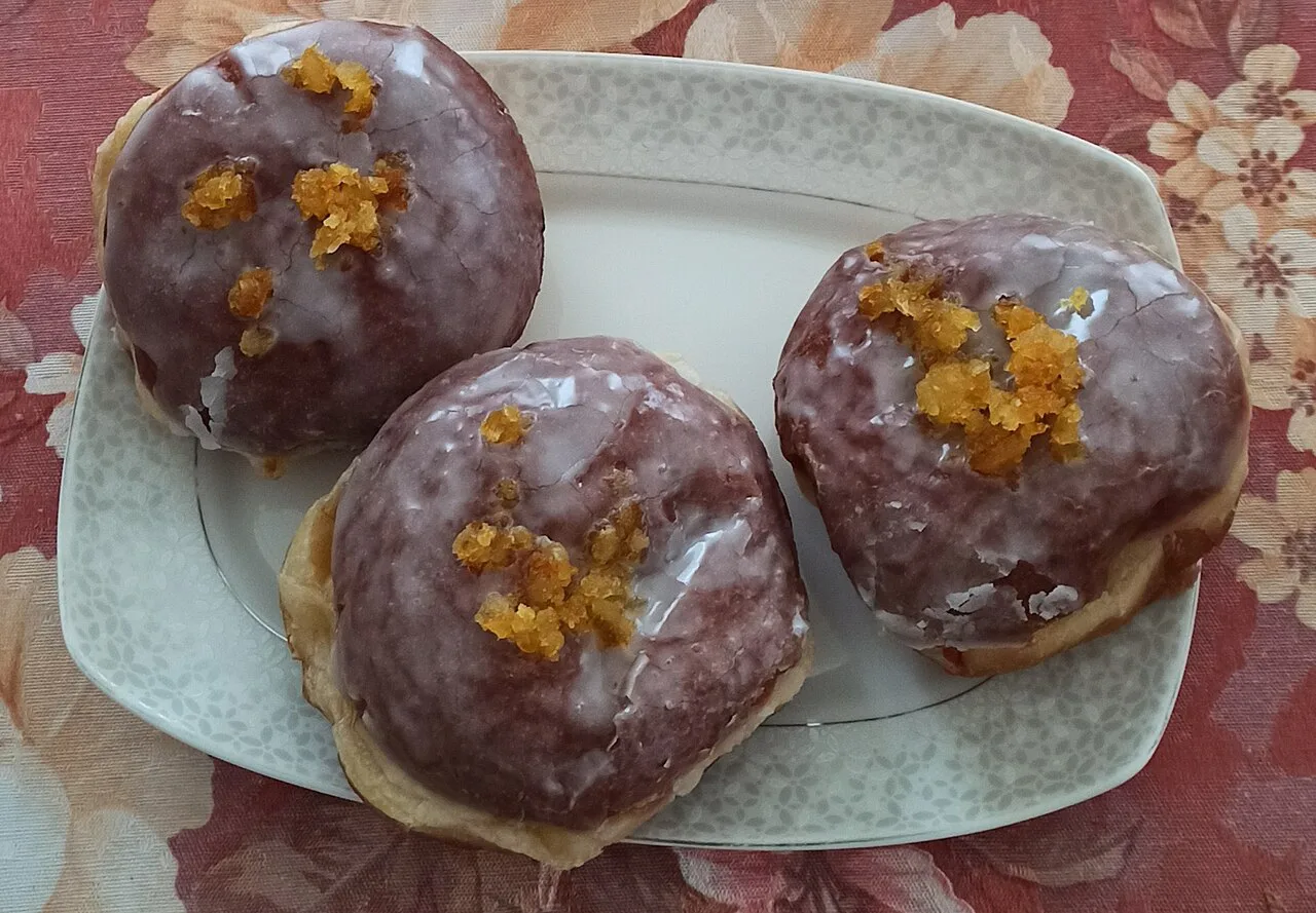 Glazed pączki topped with candied orange peel.