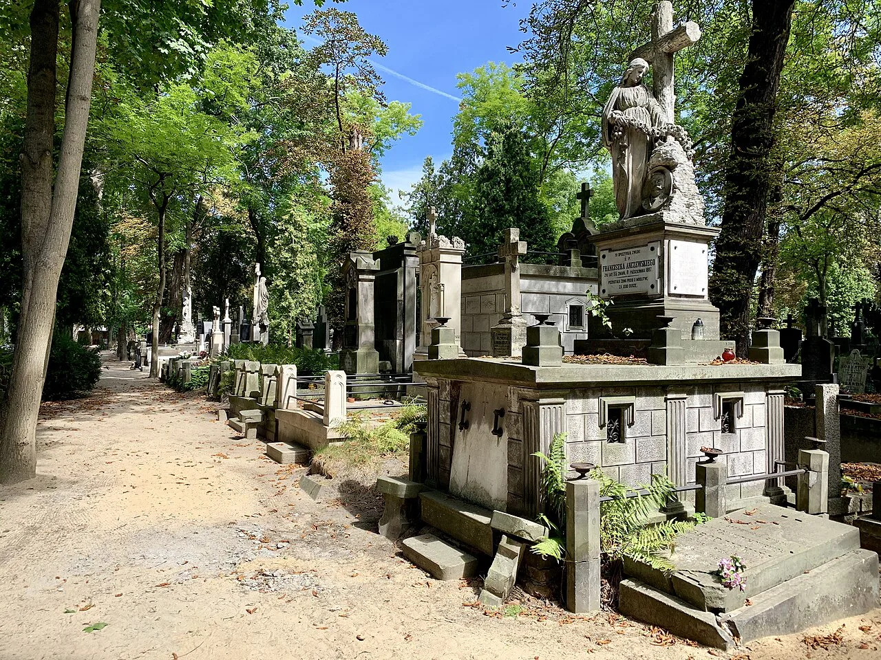 A path between historic graves at Powązki Cemetery in Warsaw.