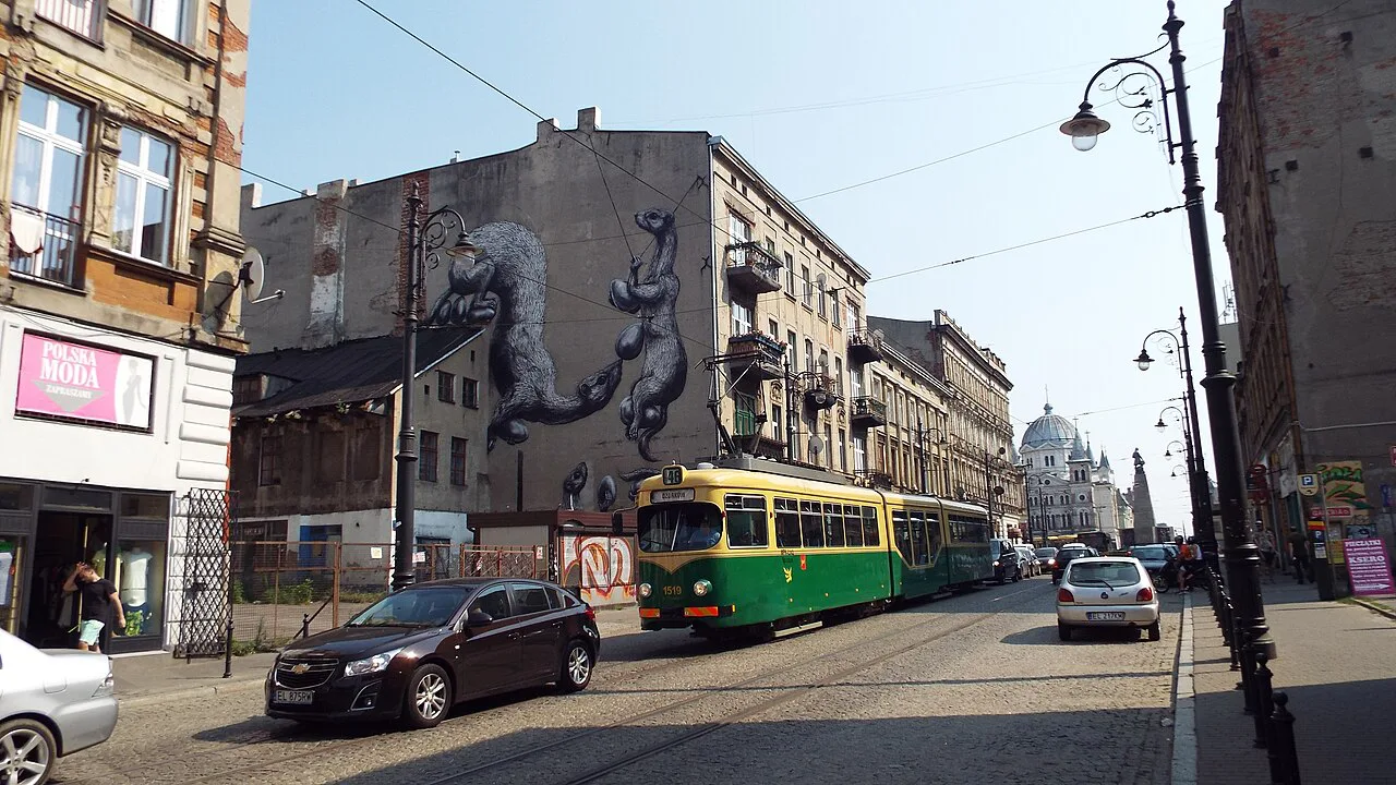 A large mural and a vintage tram in central Łódź.