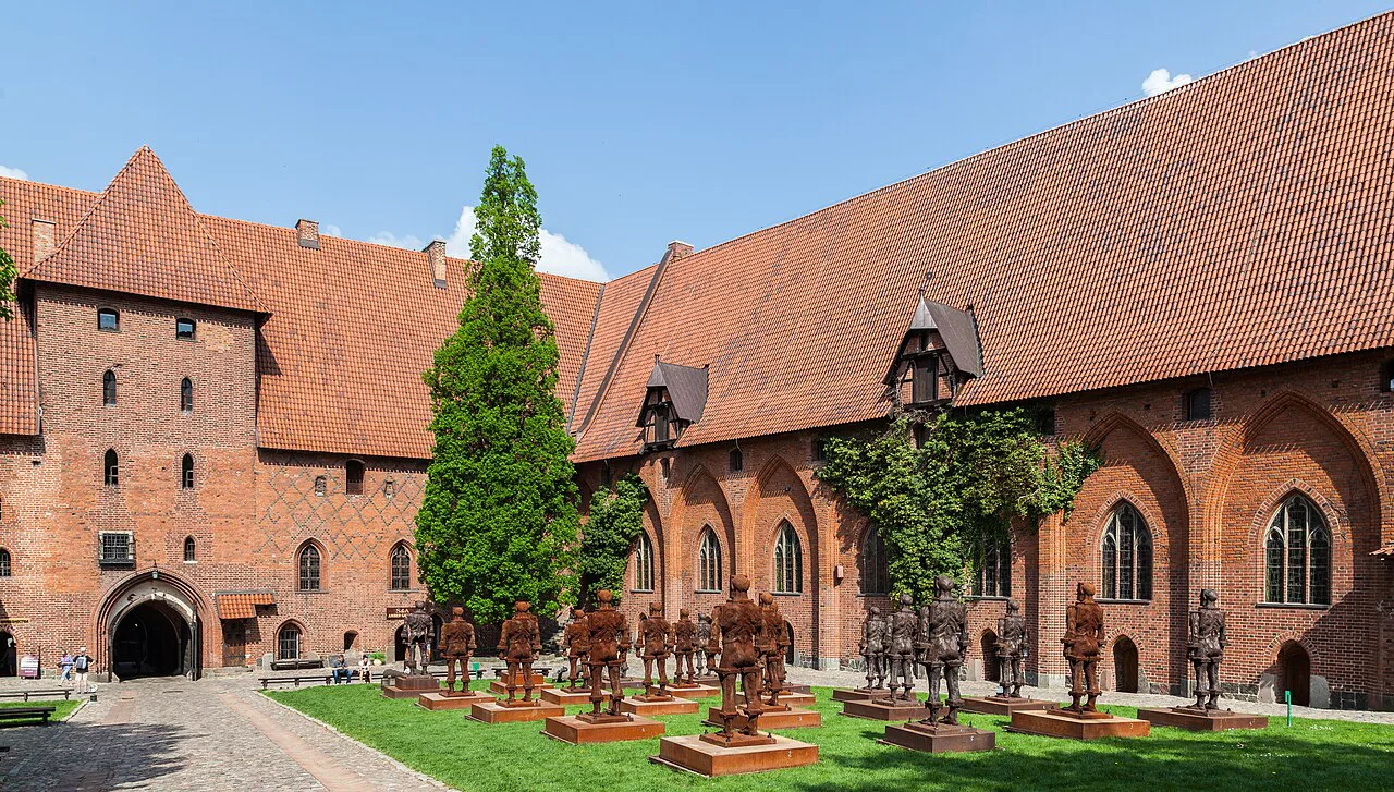 Rows of iron warrior figures in a courtyard of Malbork Castle.