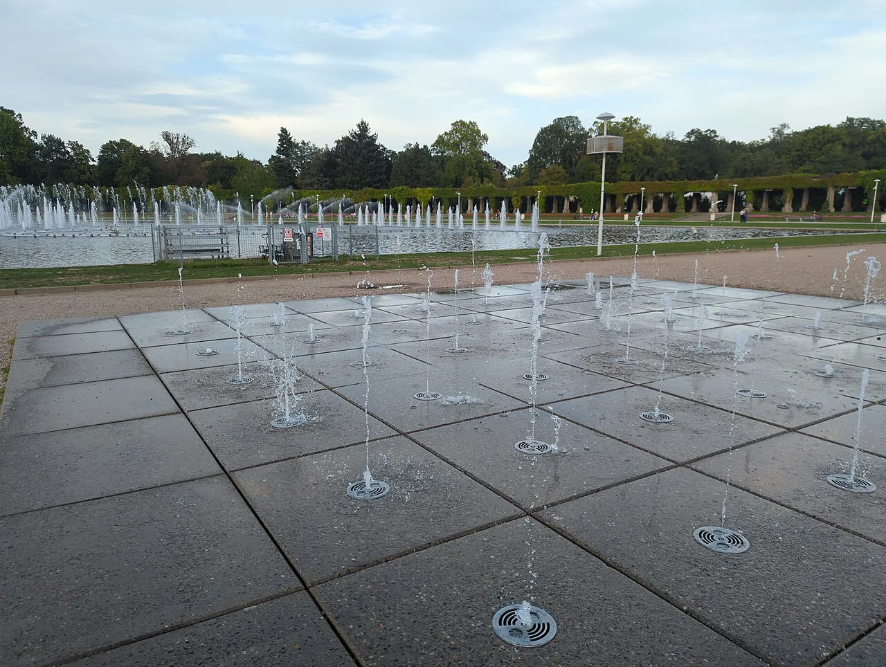 Floor jets and the main pool of the Wrocław Multimedia Fountain by day, with the Pergola behind.