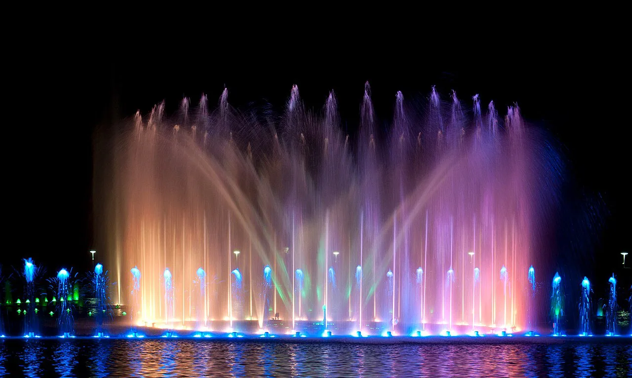 The Wrocław Multimedia Fountain lit up during an evening show.